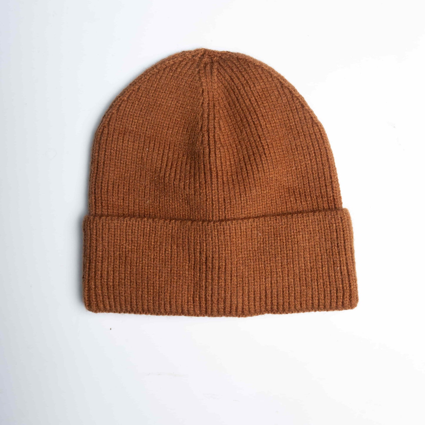 Close-up of  a brown cozy wool knitted winter cap in a classic design, showcasing its textured pattern and soft, warm material, placed on a neutral background.