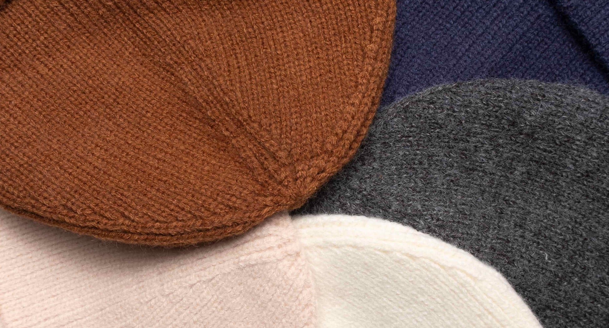 Close-up of a cozy wool knitted winter cap in a classic design, showcasing its textured pattern and soft, warm material, placed on a neutral background.