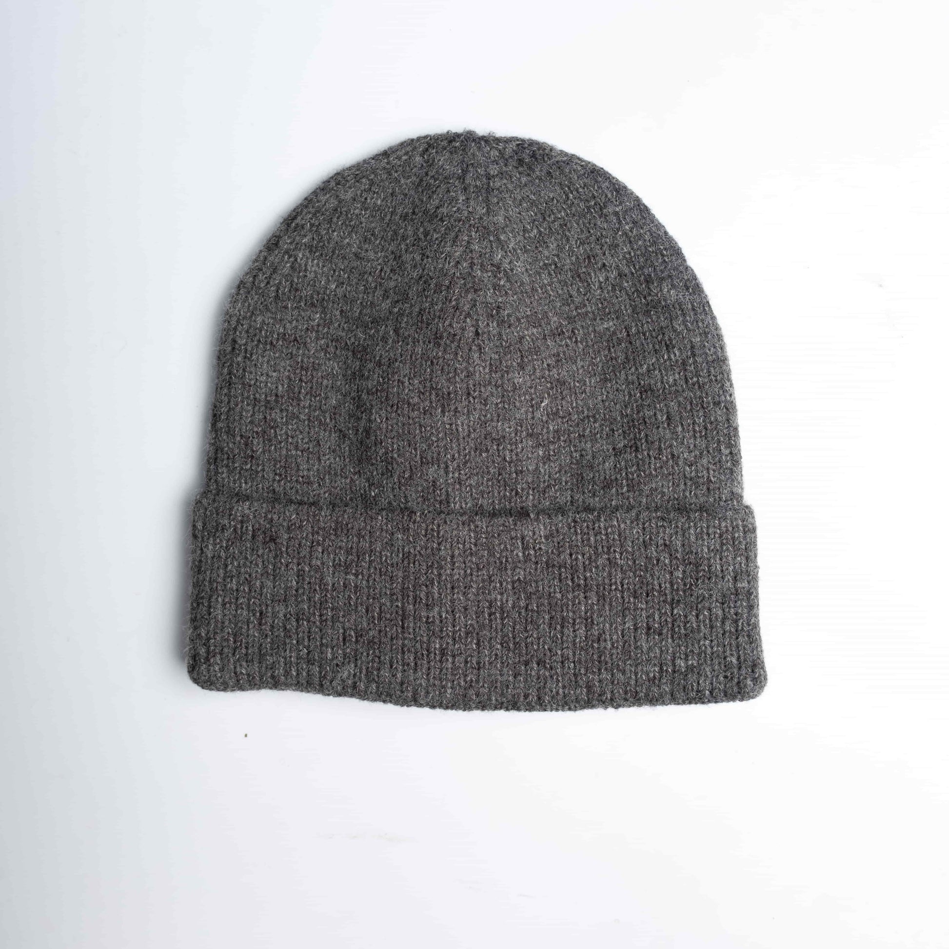 Close-up of a grey cozy wool knitted winter cap in a classic design, showcasing its textured pattern and soft, warm material, placed on a neutral background.